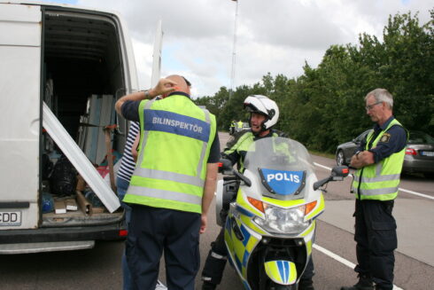 En sammanbiten rumänsk förare blir informerad av bilinspektör Krister Nilsson och trafikpoliserna Sören Johansson och Lars-Göran Samuelsson