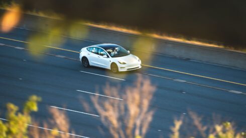  Bil som kör på en illustrerad elektrisk motorväg.