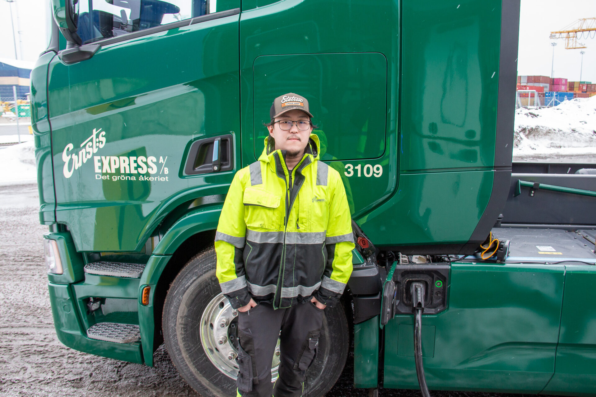 Chauffören Alexander Byggnings framför den eldrivna lastbilen, som laddas i Gävle hamn. Foto: Lisa Nordin, Gävle Hamn AB.