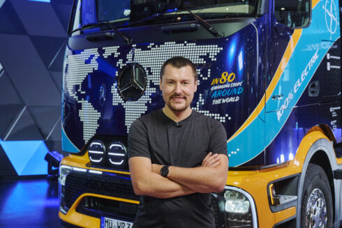 Tobias Wagner framför den eActros 600 som han ska köra omkring 4 500 mil jorden runt med. Foto: Kilian Bishop/Daimler Truck AG